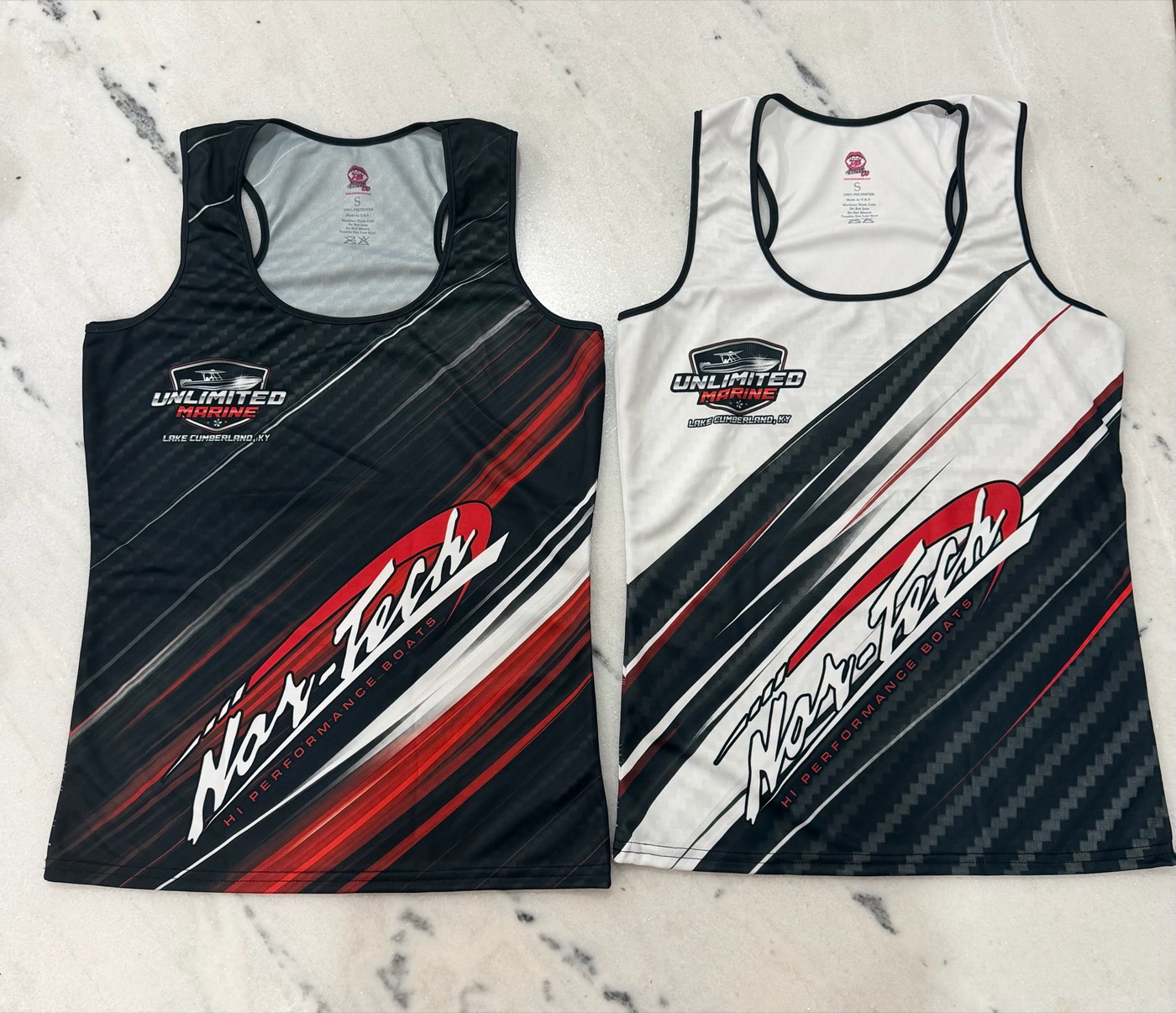 Two Unlimited Marine and Nor-Tech tank tops, one black and one white, with red and black sublimated stripes